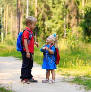 happy little boy and girl with backpacks in summer, kids go to school